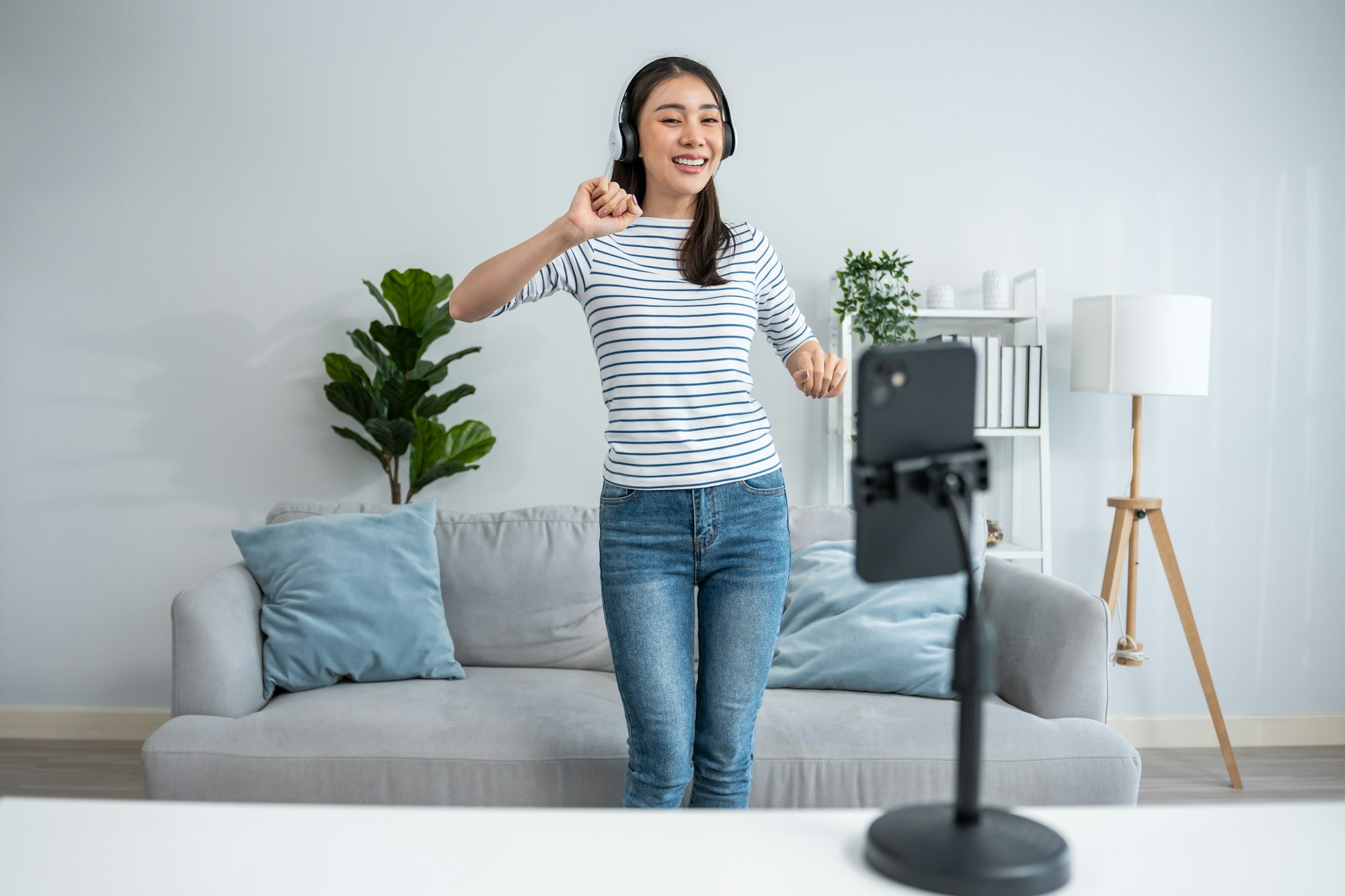 Asian attractive woman enjoy dance with music in living room at home.