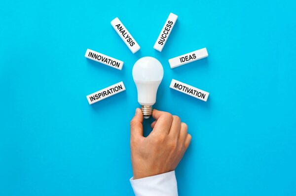 Businessman holding light bulb with wooden blocks with copy space.