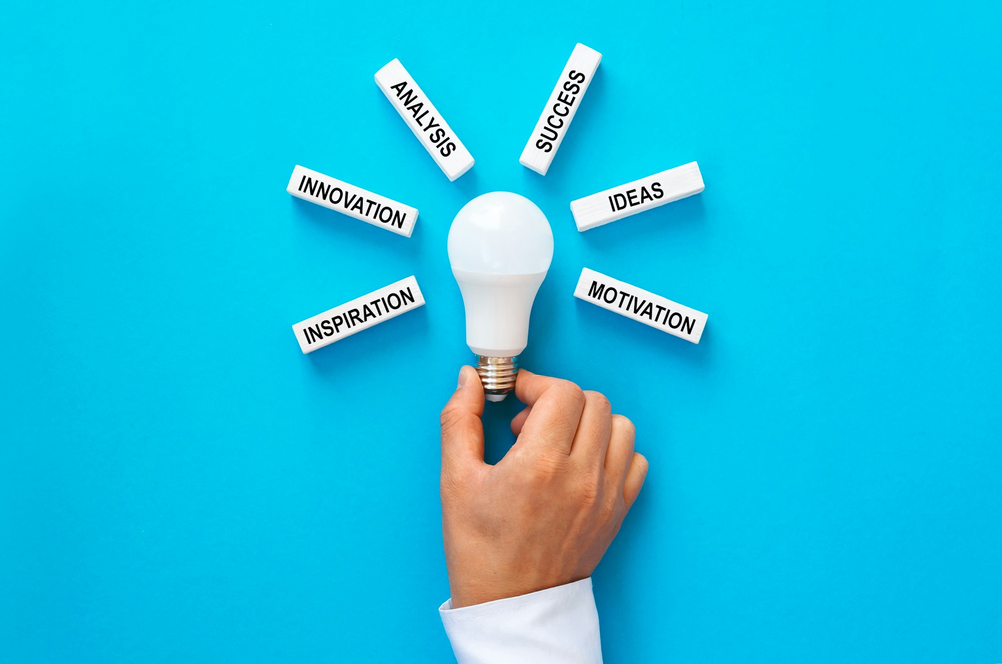 Businessman holding light bulb with wooden blocks with copy space.