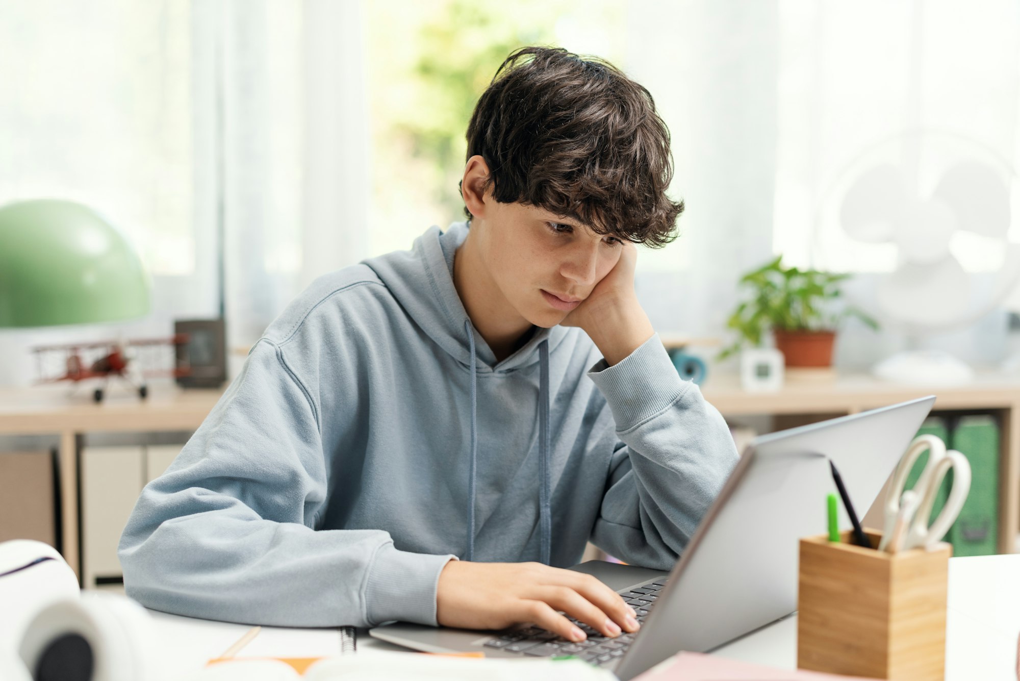 Student connecting online using his laptop