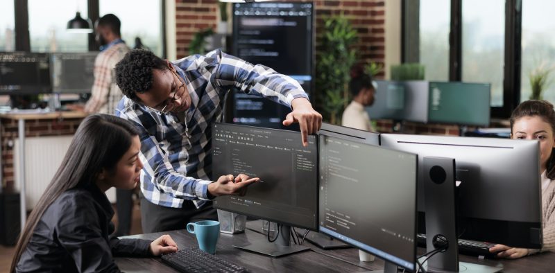 Cyber security agency coworker indicating on screen high usage of processing power on data grid