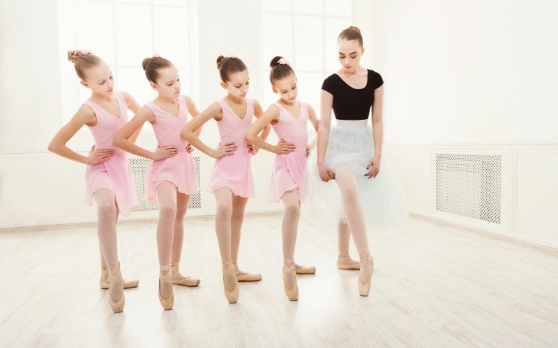 Teacher helping her students during dance class